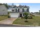 Two-story home with a two-car garage, stone accents, and a black front door at 7604 Tanglewood Way, Denver, NC 28037