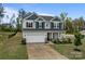 Two-story home with a two-car garage, stone accents, and beautiful landscaping at 7604 Tanglewood Way, Denver, NC 28037