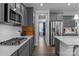 Galley kitchen with stainless steel appliances, gas range, and ample counter space, perfect for cooking enthusiasts at 7604 Tanglewood Way, Denver, NC 28037