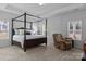 Spacious main bedroom boasts a four-poster bed and a sitting area with large windows at 7604 Tanglewood Way, Denver, NC 28037