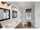 Bathroom with double sink vanity, wainscotting, and natural light from the window at 8105 Castlemaine Dr, Matthews, NC 28104