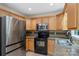 An efficient kitchen offers warm wood cabinets, granite countertops, and stainless appliances at 8302 Holbrook Square Ct, Charlotte, NC 28216