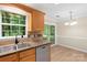 The kitchen features a stainless steel sink, warm wood cabinets, and a sliding door to the patio at 8302 Holbrook Square Ct, Charlotte, NC 28216