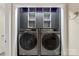 Laundry area featuring a modern washer and dryer with added storage units above at 8302 Holbrook Square Ct, Charlotte, NC 28216