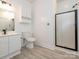 A bathroom featuring a single sink vanity, toilet, and glass-door shower stall, creating a modern and practical design at 8747 Coralbell Ln, Charlotte, NC 28213