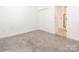 A simple bedroom features neutral walls, carpet flooring, and a closet space, creating a versatile and adaptable living area at 8747 Coralbell Ln, Charlotte, NC 28213