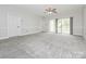 Bright bedroom with gray carpet, ceiling fan, and sliding glass doors to a private balcony at 8747 Coralbell Ln, Charlotte, NC 28213