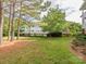 Multi-story building surrounded by green grass and mature trees, offering a serene environment at 8747 Coralbell Ln, Charlotte, NC 28213