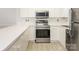 Updated kitchen features stainless steel appliances, white cabinets and light countertops at 8747 Coralbell Ln, Charlotte, NC 28213