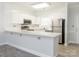 Well-lit kitchen boasts stainless steel appliances, white cabinetry, and bar seating, ideal for modern living at 8747 Coralbell Ln, Charlotte, NC 28213