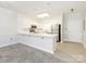 Bright kitchen features white cabinets, stainless steel appliances, and an eat-in bar area, perfect for entertaining at 8747 Coralbell Ln, Charlotte, NC 28213