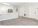 Spacious living room flows into the kitchen, featuring neutral carpets, updated trim, and ample natural light at 8747 Coralbell Ln, Charlotte, NC 28213