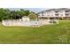 Community pool surrounded by a white fence, lush green grass, and a pool house at 8747 Coralbell Ln, Charlotte, NC 28213
