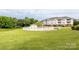 Community pool area with a white fence and building in the background, set in a grassy field at 8747 Coralbell Ln, Charlotte, NC 28213