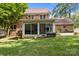 View of the backyard featuring an enclosed porch, brick exterior, and expansive lawn at 9001 Peyton Randolph Dr, Charlotte, NC 28277