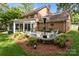 Outdoor stone patio with seating, heat lamp, and view of the home's brick exterior and enclosed porch at 9001 Peyton Randolph Dr, Charlotte, NC 28277