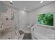 Luxurious bathroom featuring a marble walk-in shower and a separate soaking tub at 9001 Peyton Randolph Dr, Charlotte, NC 28277