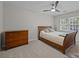 This bedroom features a wood-framed bed, neutral walls, and a modern ceiling fan with an integrated light at 9001 Peyton Randolph Dr, Charlotte, NC 28277