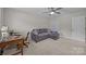 Bright and airy bedroom with a grey couch, a computer, and a ceiling fan for a comfortable stay at 9001 Peyton Randolph Dr, Charlotte, NC 28277
