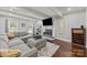 Cozy living room features a fireplace, gray sectional, and bright windows at 9001 Peyton Randolph Dr, Charlotte, NC 28277