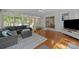 Bright sunroom with hardwood floors, large windows, and comfortable gray sectional sofa at 9001 Peyton Randolph Dr, Charlotte, NC 28277