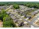 Aerial view of a neighborhood with many homes, mature trees, and a pond at 9132 Colwick Hill Ln, Charlotte, NC 28215