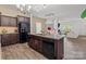 Kitchen area featuring an island with granite counters, wood cabinets, and stainless steel appliances, with open dining room at 9132 Colwick Hill Ln, Charlotte, NC 28215