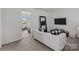 Living room featuring a white sofa, mounted TV, and a view into the adjacent bedroom at 9132 Colwick Hill Ln, Charlotte, NC 28215