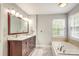 Bright bathroom with a double vanity, large mirror, and soaking tub near a window at 916 Cadogan Ct, Fort Mill, SC 29708