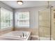 Bathroom boasts a soaking tub next to the windows and a glass enclosed shower at 916 Cadogan Ct, Fort Mill, SC 29708