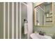 Stylish powder room with decorative mirror, patterned accent wall, and modern fixtures at 916 Cadogan Ct, Fort Mill, SC 29708