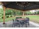 Backyard gazebo with a table and chairs on a stone patio, surrounded by greenery at 916 Cadogan Ct, Fort Mill, SC 29708