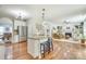 Open concept kitchen features island with bar seating and overlooks the living room with fireplace at 916 Cadogan Ct, Fort Mill, SC 29708
