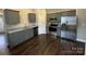 Modern kitchen with gray cabinetry, stainless steel appliances, granite countertops, and hardwood floors at 003 West Ave, Wadesboro, NC 28170