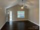 Spacious living room with vaulted ceiling, hardwood floors, a ceiling fan, and ample natural light at 003 West Ave, Wadesboro, NC 28170