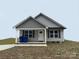 Charming single-story home featuring gray siding, a covered porch, and black shutters at 004 West Ave, Wadesboro, NC 28170