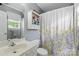 Well-lit bathroom features a gray wall color and decorative flower-themed shower curtain at 1006 Washburn Ct, Monroe, NC 28110