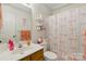 Bright bathroom featuring wooden vanity, mirror, and shower with pink bow curtain at 1006 Washburn Ct, Monroe, NC 28110