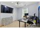 Neutral toned bedroom featuring a work space with a desk and a mounted television at 1006 Washburn Ct, Monroe, NC 28110