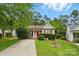 Charming one-story home featuring red accents, manicured lawn and mature trees at 1006 Washburn Ct, Monroe, NC 28110
