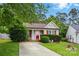 Charming one-story home featuring red accents, manicured lawn and mature trees at 1006 Washburn Ct, Monroe, NC 28110