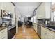 Open kitchen with stainless steel appliances and wood floors open to dining area at 1006 Washburn Ct, Monroe, NC 28110