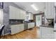 Open kitchen features stainless steel appliances, wood floors, and dark backsplash at 1006 Washburn Ct, Monroe, NC 28110