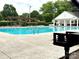 Community pool with crystal-clear water, pergola, and plenty of seating for relaxing in the sun at 1006 Washburn Ct, Monroe, NC 28110
