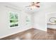 Bright bedroom with hardwood floors, neutral walls, ceiling fan, and natural light from the two windows at 10901 Greenvale Dr, Harrisburg, NC 28075
