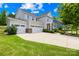 Charming two-story home with a three-car garage and lush green lawn, bathed in sunlight at 10901 Greenvale Dr, Harrisburg, NC 28075