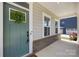 Close-up of a charming front door with a wreath, complemented by a brick facade and side windows at 10901 Greenvale Dr, Harrisburg, NC 28075