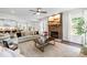 Cozy living room with a stone fireplace, plush seating, and seamless flow to an adjacent kitchen area at 10901 Greenvale Dr, Harrisburg, NC 28075