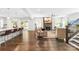 Open-concept living space connecting a modern kitchen, cozy living room with a stone fireplace, and outdoor access at 10901 Greenvale Dr, Harrisburg, NC 28075