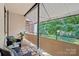 Relaxing covered balcony with outdoor seating and a view of the lush green trees in the neighborhood at 1121 Myrtle Ave # 72, Charlotte, NC 28203